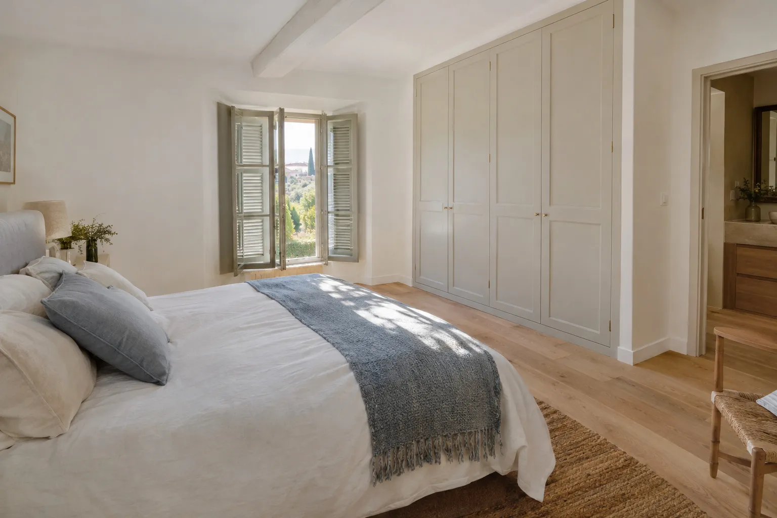 Chambre rénovée avec parquet clair et grand placard intégré